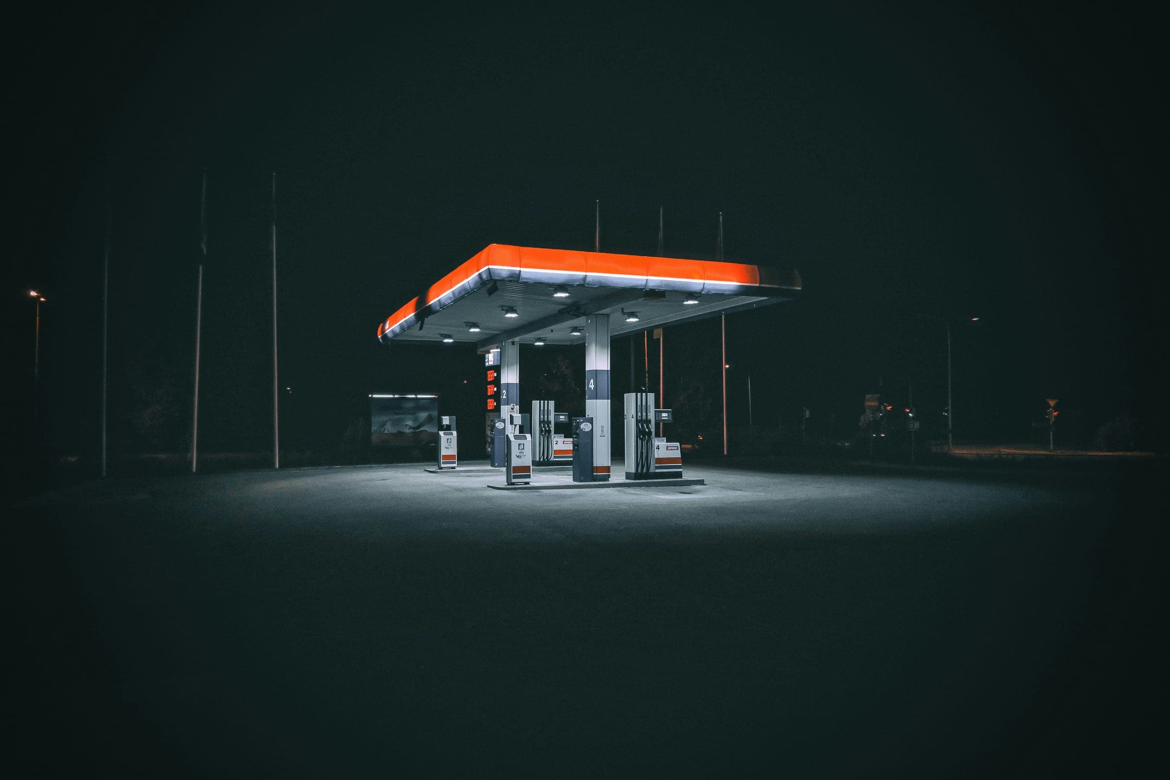 A lit gas station canopy alone in the dark
